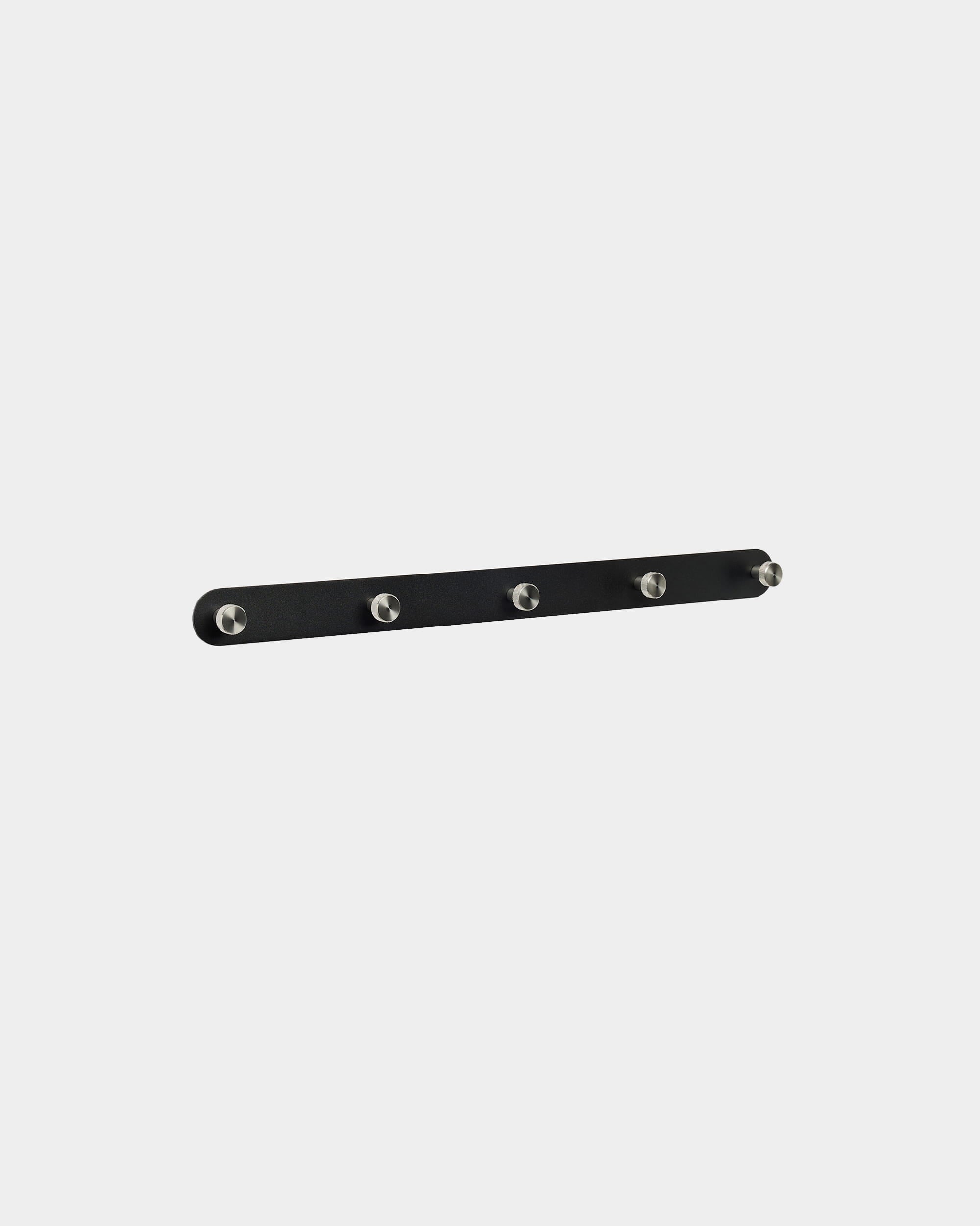 Cabide de parede WoodUpp Norr X5 em black e steel inoxidável, com cinco ganchos espaçados de forma uniforme, montado sobre um fundo branco liso. Design nórdico minimalista.