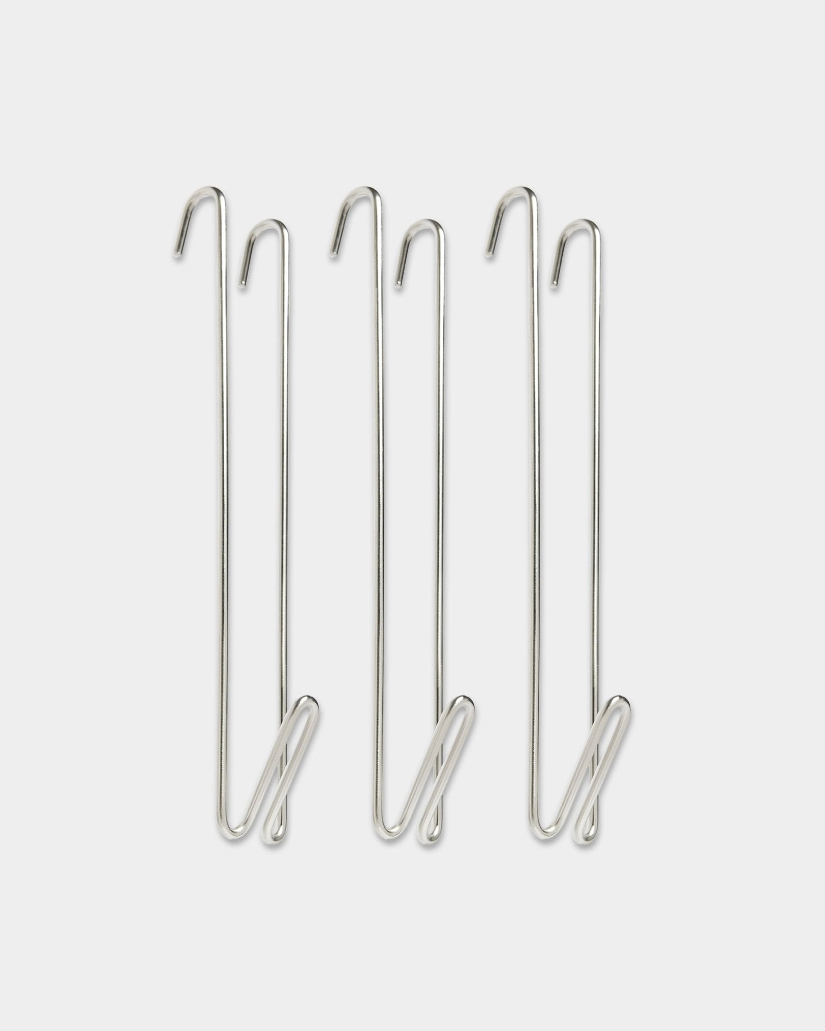 Três extensores de varão para cabides WoodUpp Alva em aço inoxidável, com ganchos de arame steel BM1, concebidos para acrescentar mais espaço para pendurar junto a painéis acústicos de madeira.