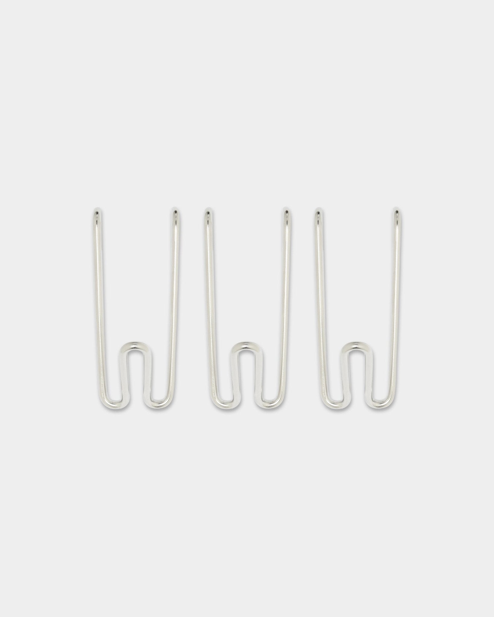 Três Alva Wire Hooks BM1, curtos, em aço inoxidável steel da coleção CREATE da WoodUpp, espaçados de forma uniforme sobre um fundo branco liso.