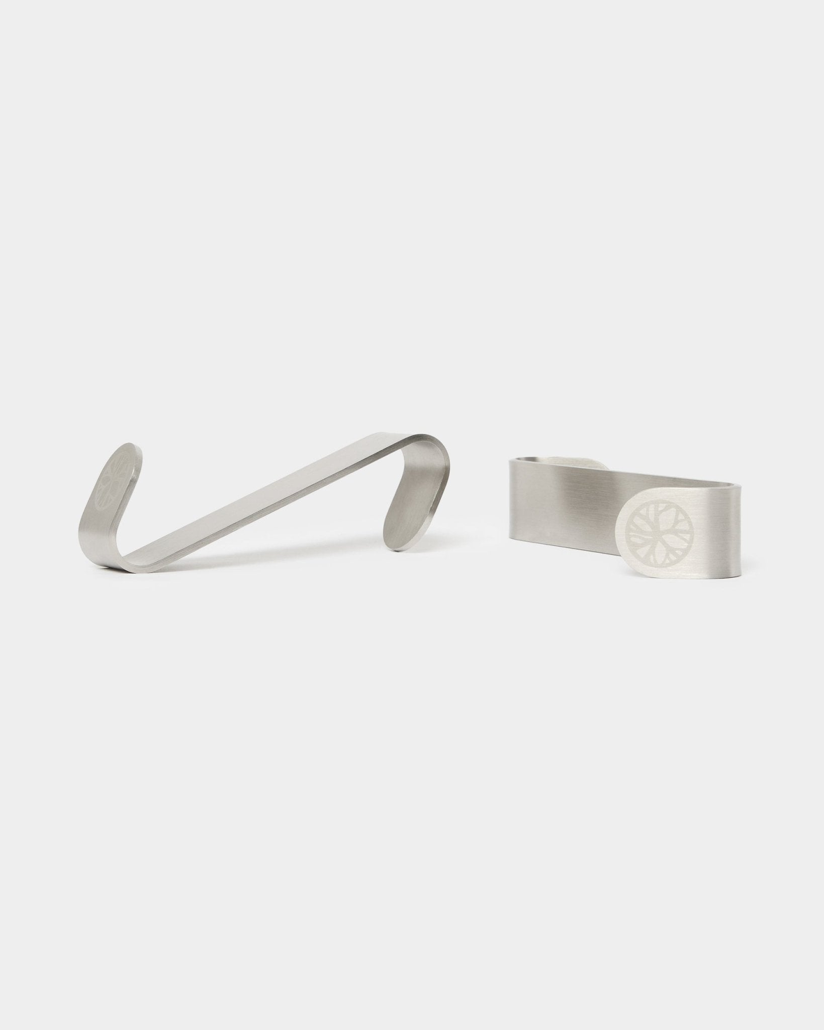 Gancho Alva S-Hook da WoodUpp BM1 e clipes para notas BM2, dois acessórios em steel inoxidável com desenhos de roda gravados, concebidos para painéis acústicos nórdicos em madeira.