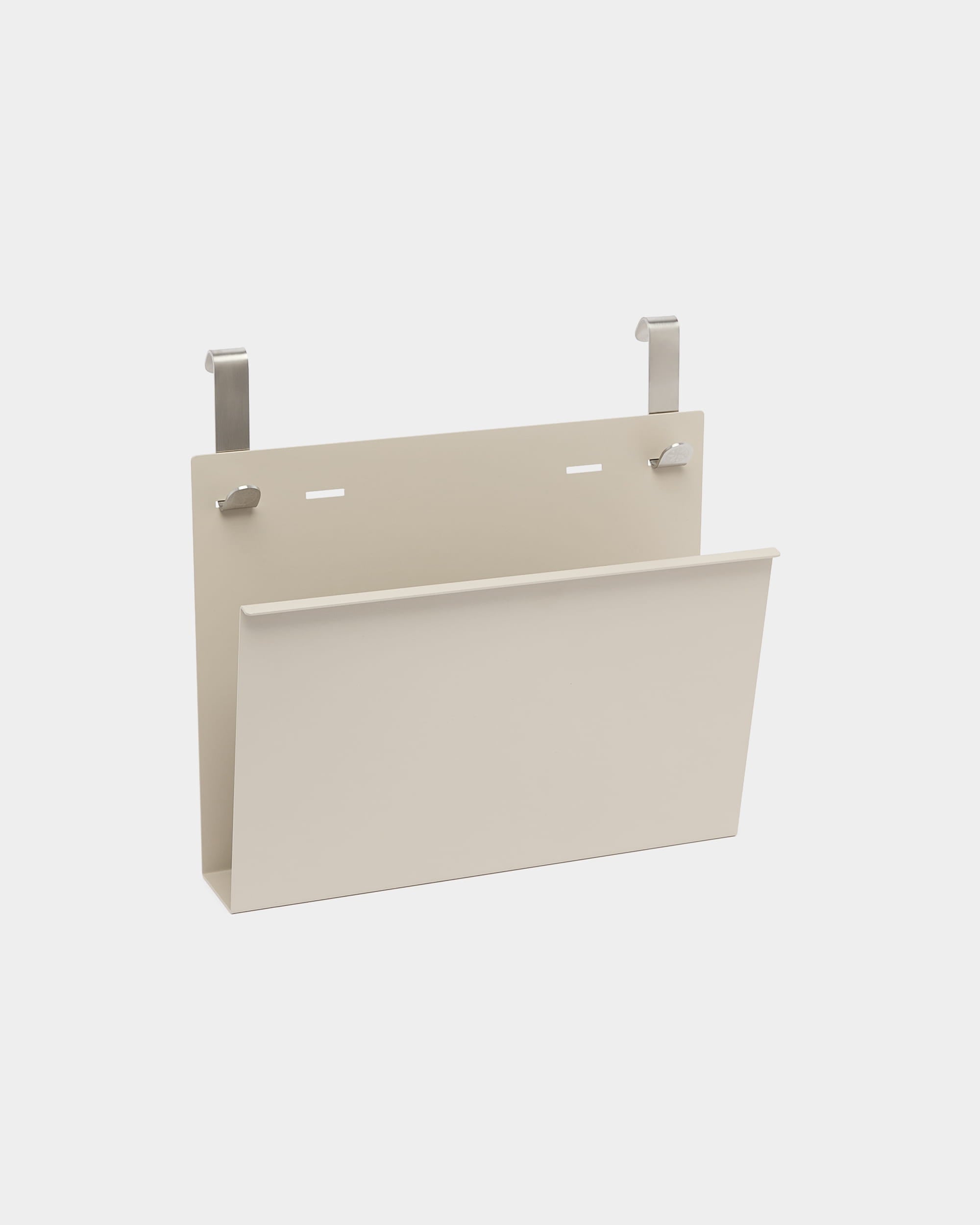 O Nell Magazine Storage da WoodUpp é um suporte em steel com revestimento a pó beige, com dois ganchos prateados para pendurar em divisórias acústicas nórdicas ou separadores de ambientes.