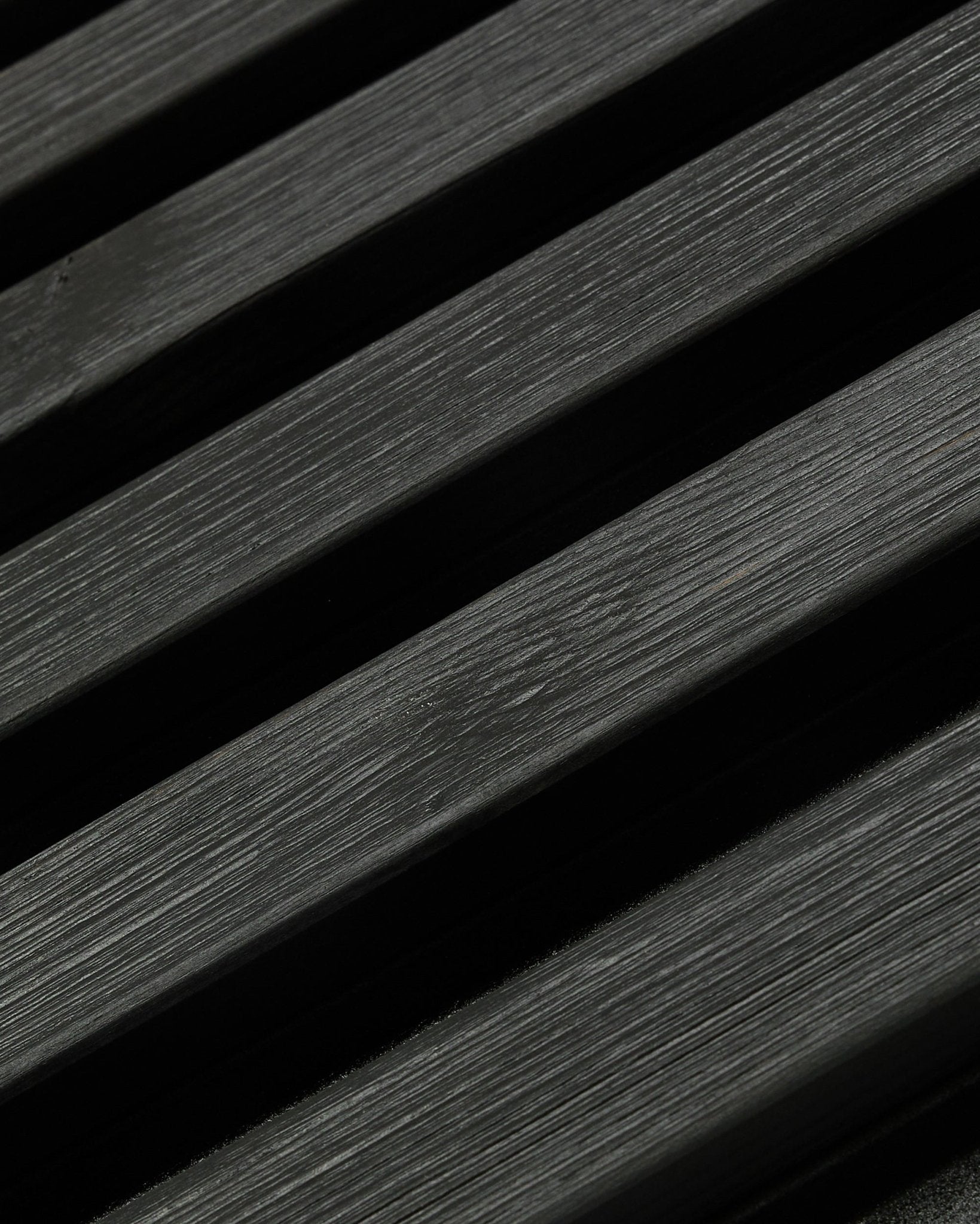 Painel de fachada exterior Aluwood da WoodUpp, em Thermowood com acabamento black, 240 x 45,1 cm, com ripas diagonais de abeto nórdico, veio visível e jogo de sombras.