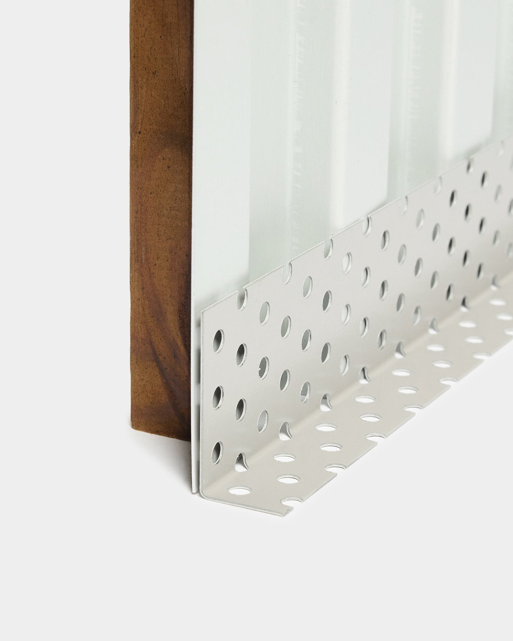 Pormenor do acessório de instalação do painel de fachada Aluwood: perfil de canto metálico com perfurações redondas large, concebido para cavidades ventiladas, comprimento de 240 cm.