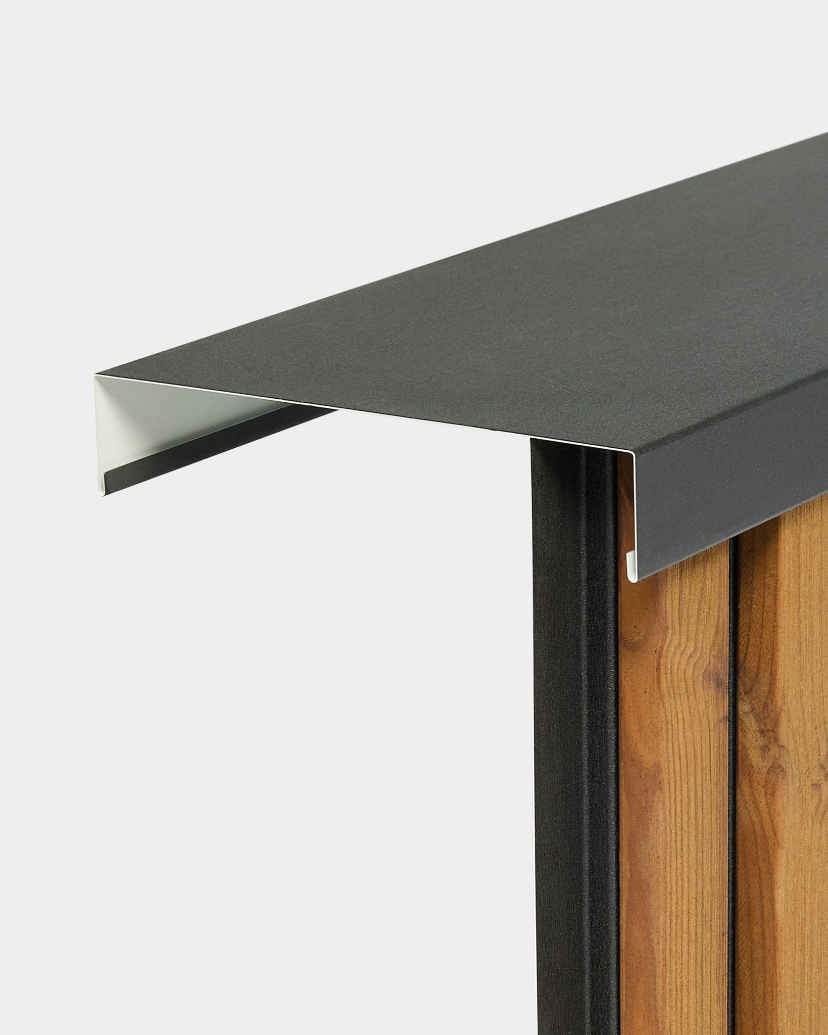 O capeamento de parede WoodUpp Aluwood Level (240 cm x 20 cm) assenta no topo de uma vedação de madeira e apresenta um perfil de alumínio com revestimento a pó black que se projeta para o exterior.