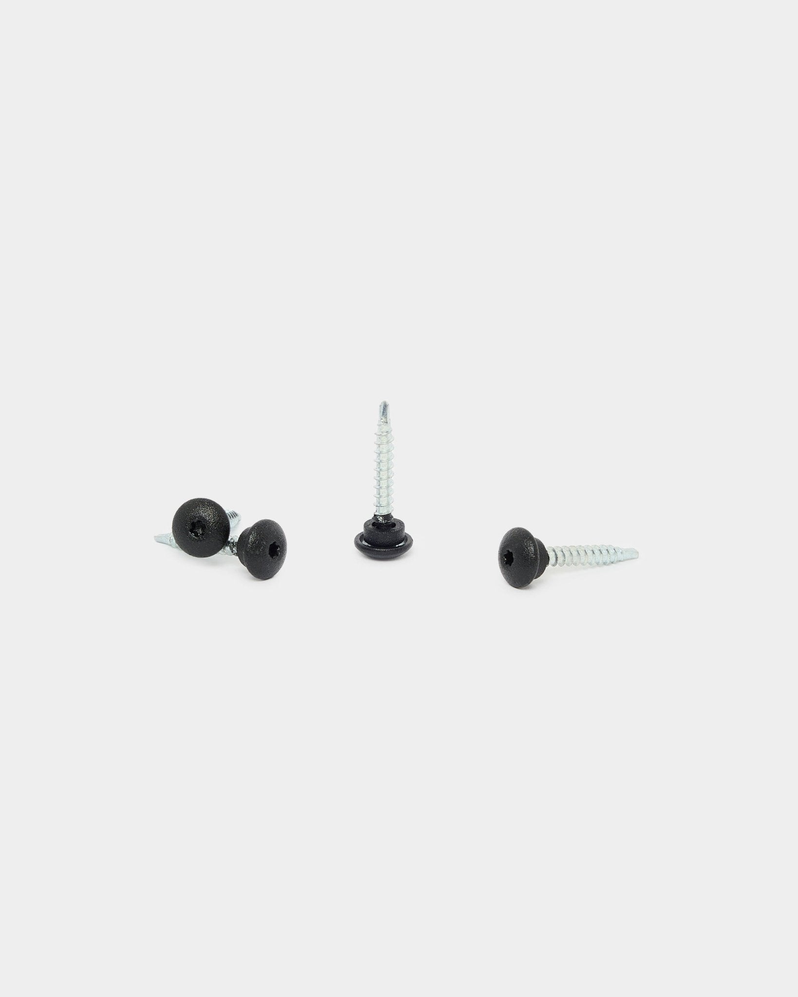 Três parafusos frontais WoodUpp black 4.8x35 com anilhas Ø9.5, concebidos para painéis acústicos Akupanel, sobre fundo branco: um na vertical, dois deitados.