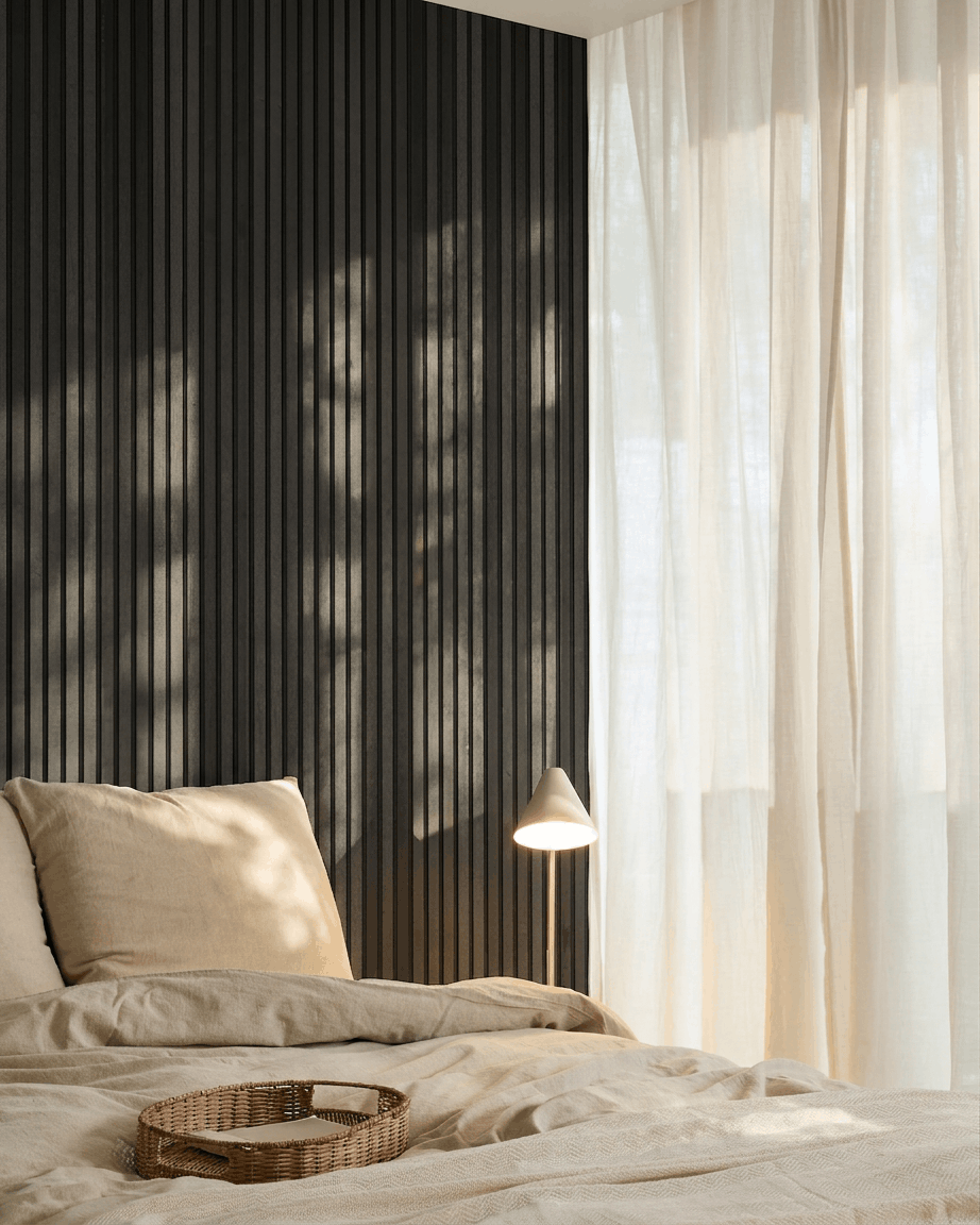 Quarto nórdico minimalista com um Akupanel Painel acústico da WoodUpp em Black Ash, roupa de cama beige, uma bandeja de vime e cortinas leves que deixam entrar luz natural.
