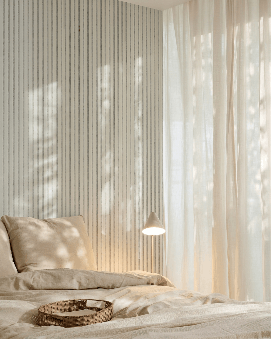 Quarto minimalista com roupa de cama beige, uma bandeja de verga, papel de parede às riscas e um painel acústico de madeira Akupanel da WoodUpp em feltro Snow Grey para absorção sonora.