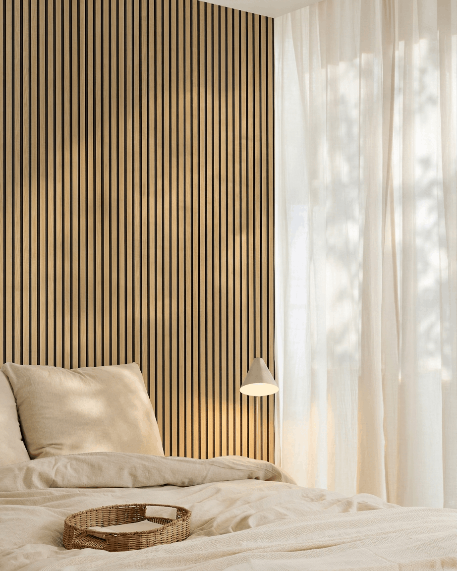 Quarto minimalista com roupa de cama beige, uma parede de destaque WoodUpp Akupanel Southern Oak Painel acústico, tabuleiro entrançado sobre a cama e cortinas leves que deixam entrar a luz natural.