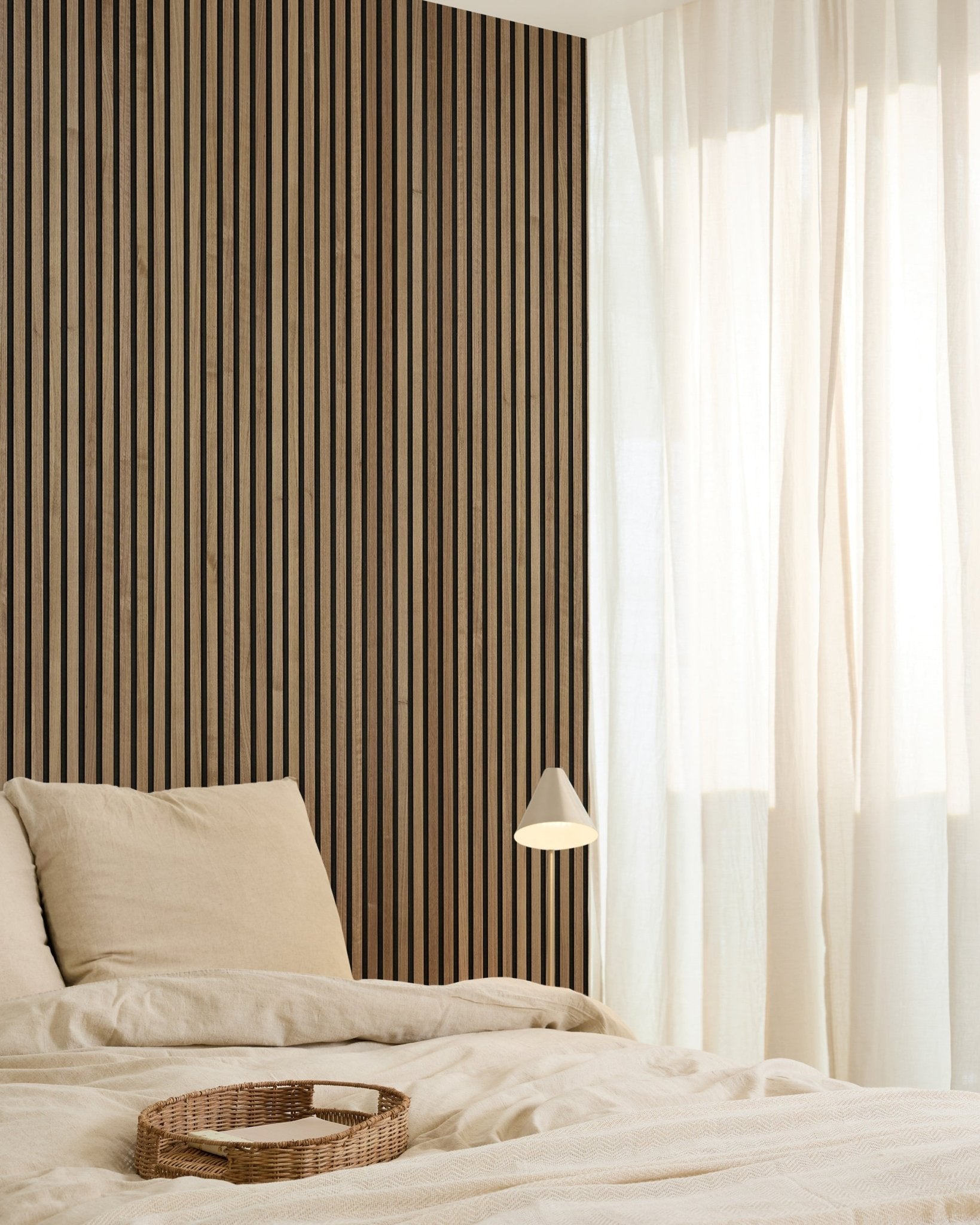 Quarto minimalista com um WoodUpp Original Akupanel Walnut Painel acústico (240x60cm) na parede, roupa de cama beige, cortinas translúcidas, tabuleiro entrançado e candeeiro de parede small.