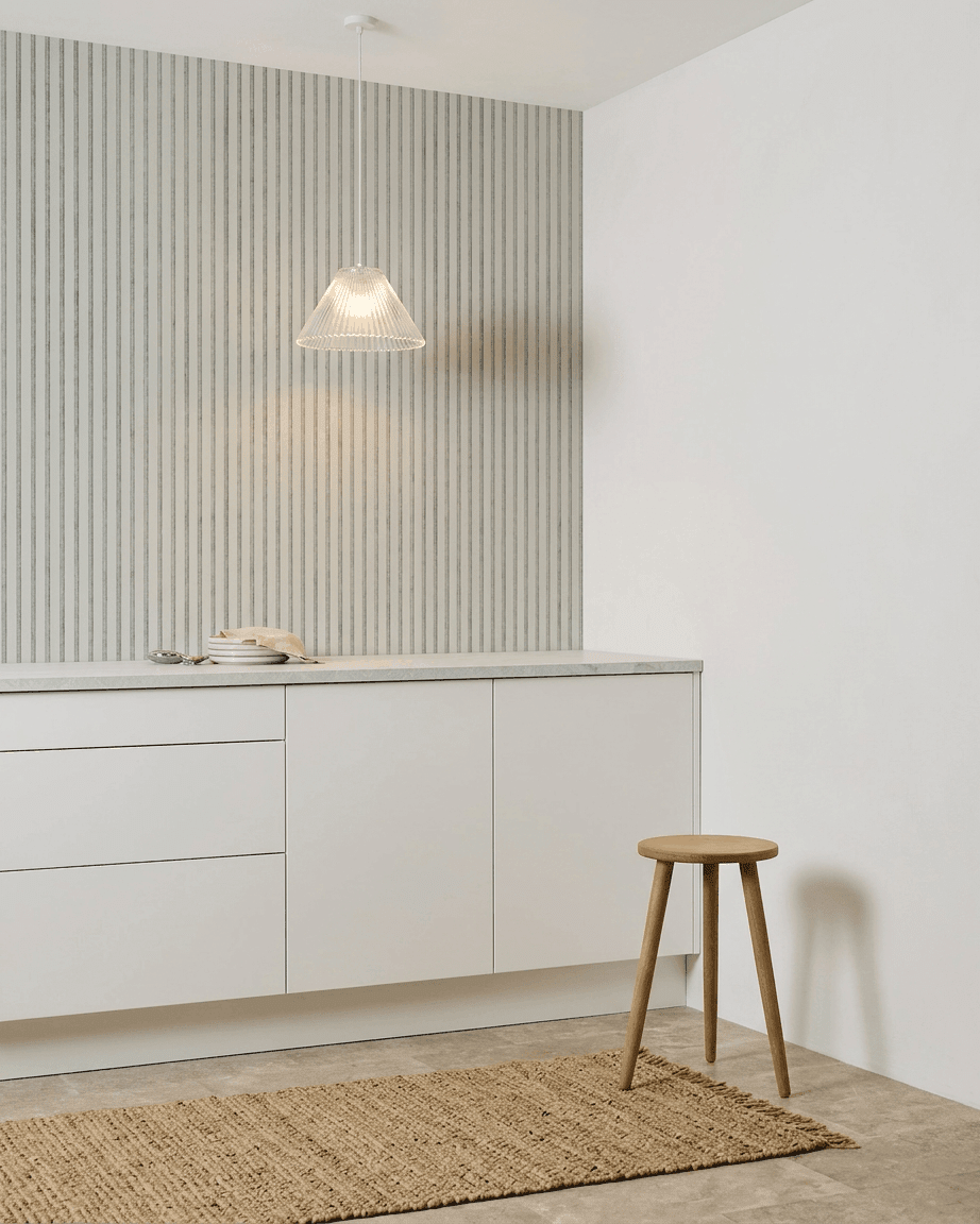 Cozinha minimalista com armários brancos, banco de madeira, tapete entrançado e um Akupanel Snow da WoodUpp Painel acústico instalado para absorção sonora.