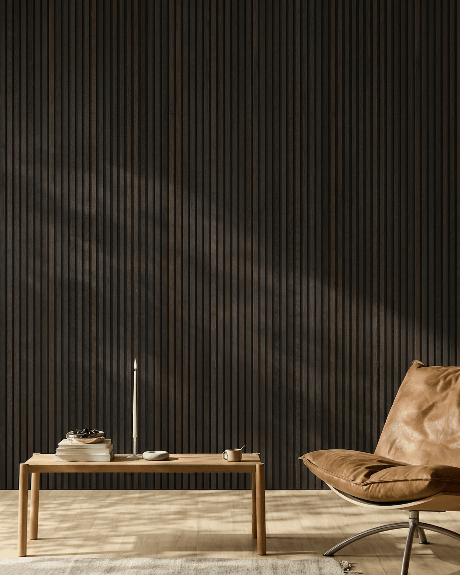 Espaço minimalista com uma cadeira em pele brown, mesa de centro e decoração em frente a uma parede com painel acústico de madeira WoodUpp Akupanel Rustic Smoked Oak.