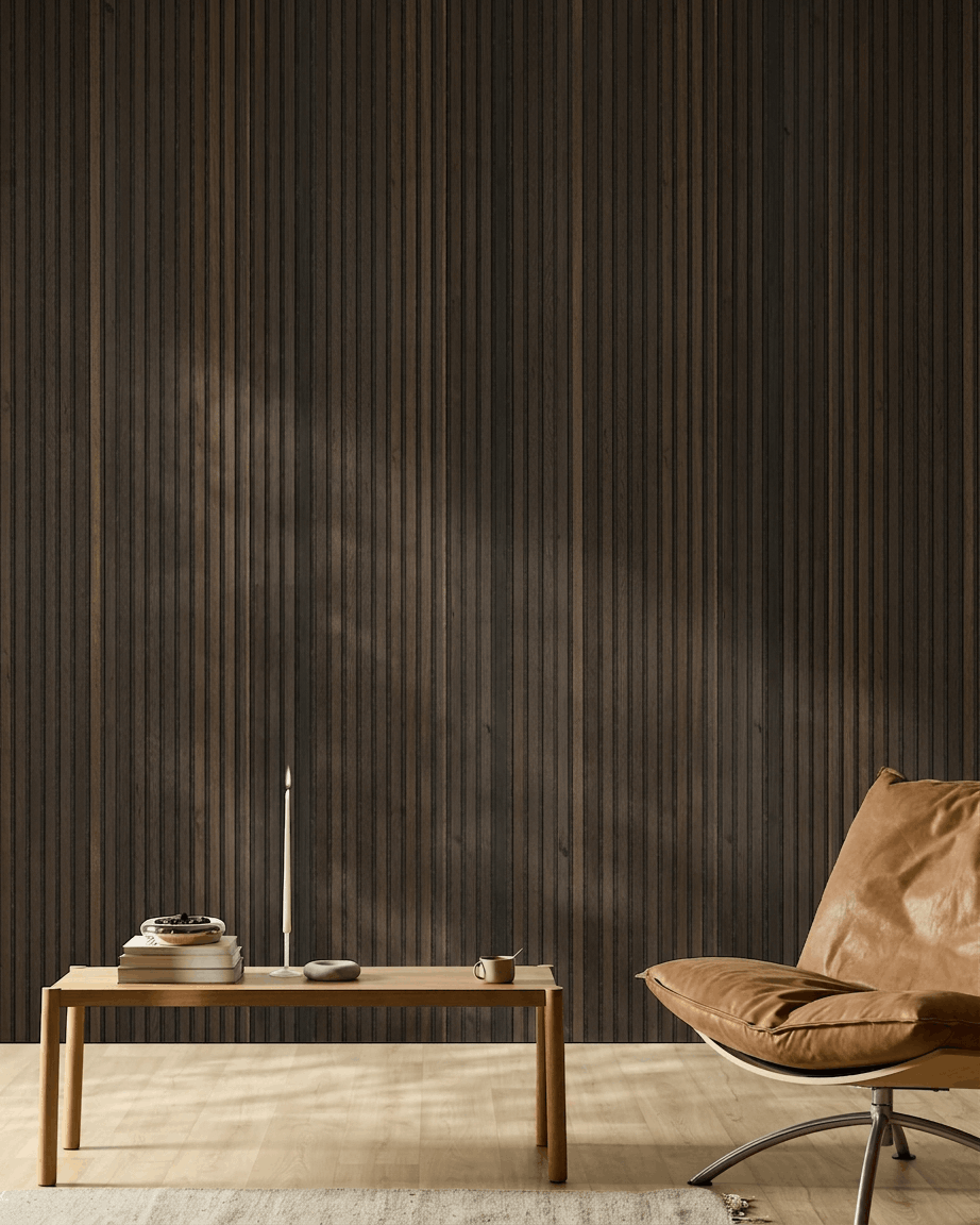 Espaço nórdico minimalista com cadeira em pele castanha, mesa de madeira, vela e chávena, diante de uma parede WoodUpp Akupanel Natural Wood Rustic Smoked Oak Painel acústico.