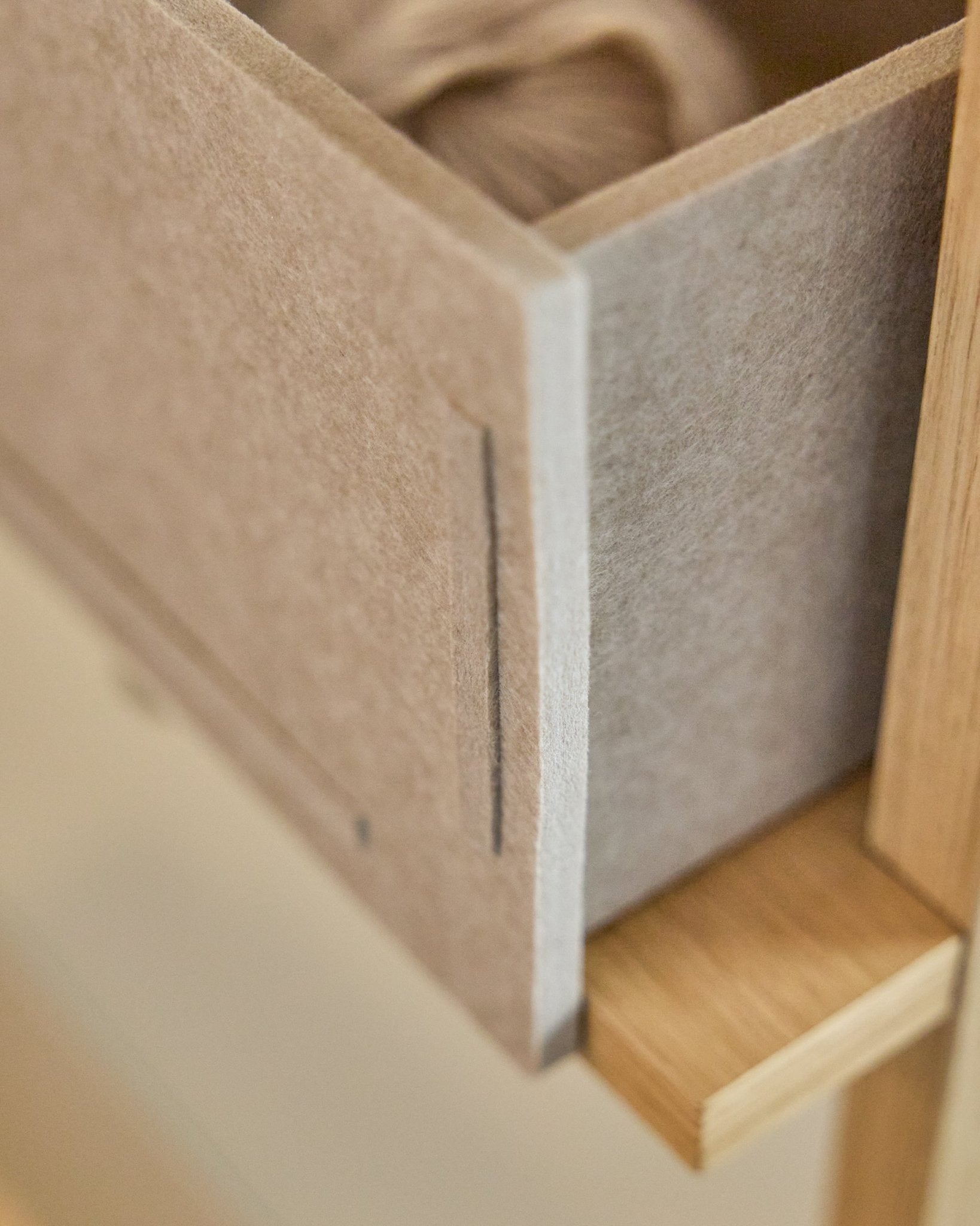 A Vigg Felt Box / BM2 em Beige da WoodUpp, uma gaveta em feltro PET com estrutura de madeira, foi pensada para arrumação em tons neutros e é compatível com sistemas Akupanel.