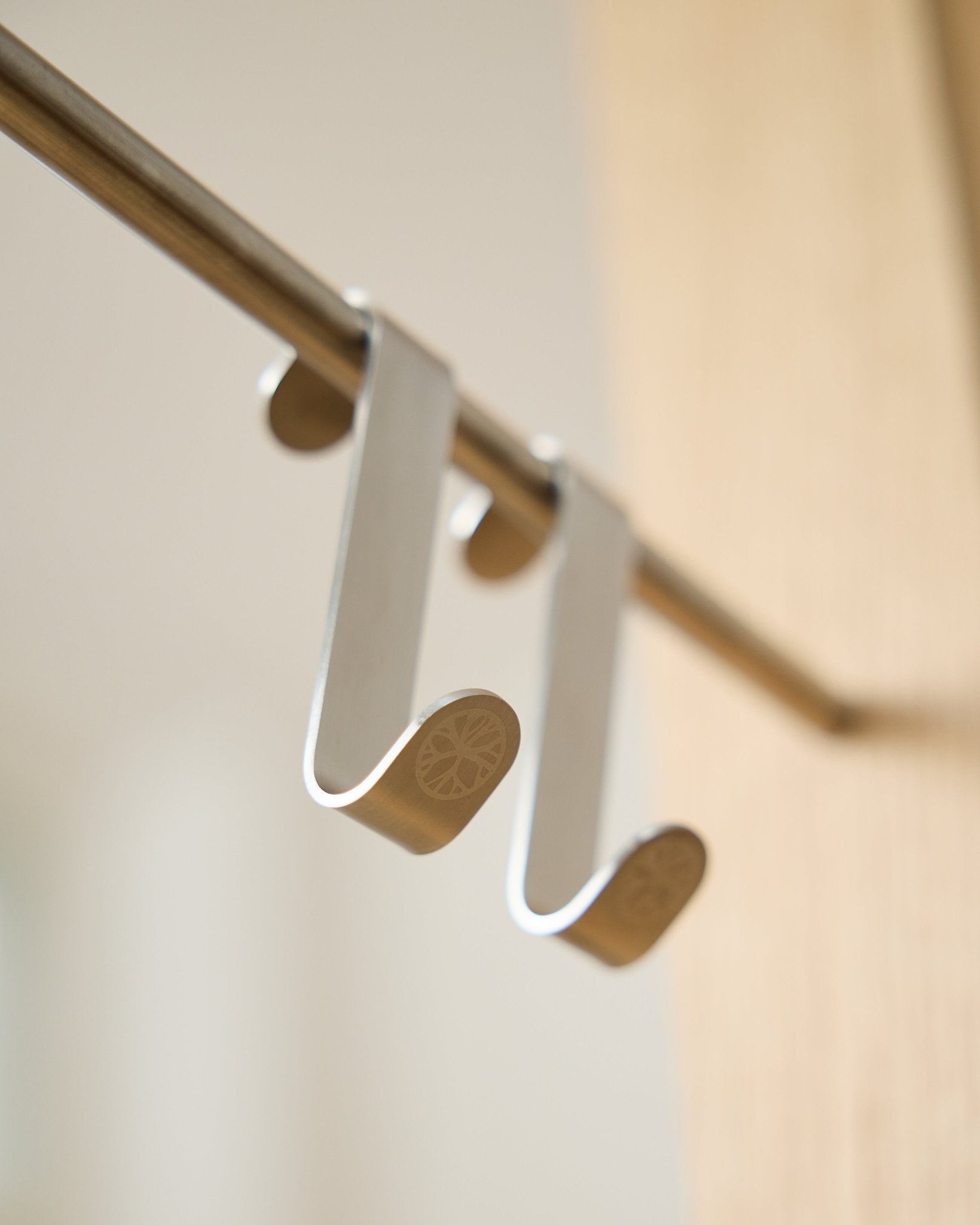 Alva S-Hook BM1  BM2 da WoodUpp, dois ganchos em steel inoxidável com extremidades planas gravadas, concebidos para pendurar acessórios em hastes Akupanel horizontal.