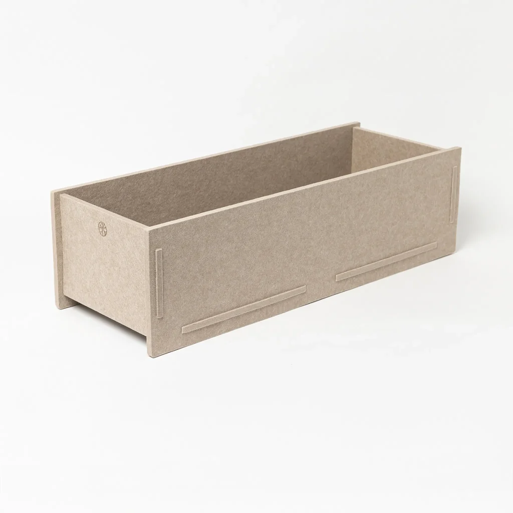 Vaso retangular da WoodUpp, em madeira/MDF cru cor bege-acinzentada, com laterais altas e encaixes visíveis; acabamento texturizado e logotipo WoodUpp gravado na face. Design modular e minimalista, ideal como caixa de plantas, organizador ou jardineira; montagem por encaixe, sem parafusos, com cantos retos e base elevada.
