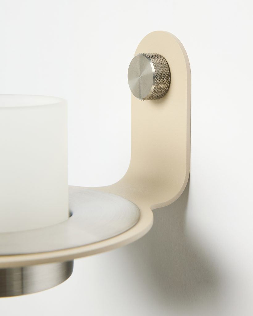 Imagem do suporte de parede WoodUpp: um porta-vela minimalista em metal bege com acabamento acetinado, base circular e copo de vidro fosco para vela, preso por um parafuso estriado em aço escovado que destaca o design funcional e elegante contemporâneo.